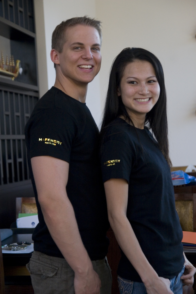 Arne und Sawittree präsentieren die gold-schwarzen T-Shirts des Tai Tan