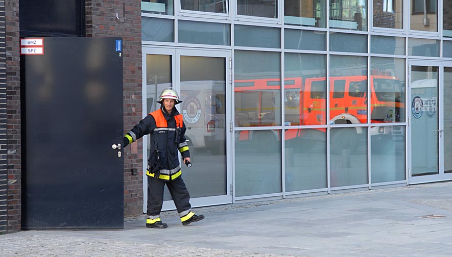 Falscher Alarm: Ein Zugführer der Feuerwehr verlässt nach einer Überprüfung das Gebäude Am Kaiserkai 13